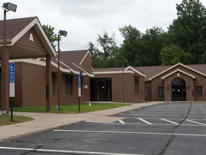 View of Green Street Primary Care from the parking lot, a dark brown building with A and B entrances