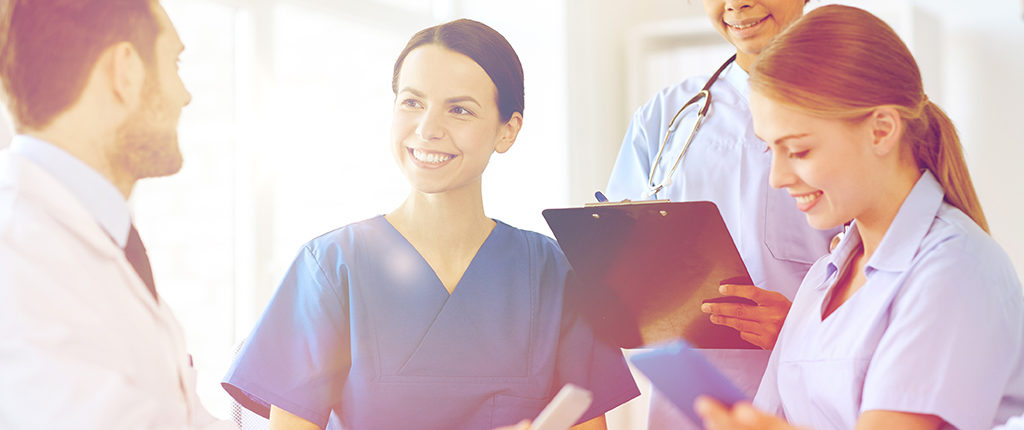 A gathering of medical professionals around a table with clipboards