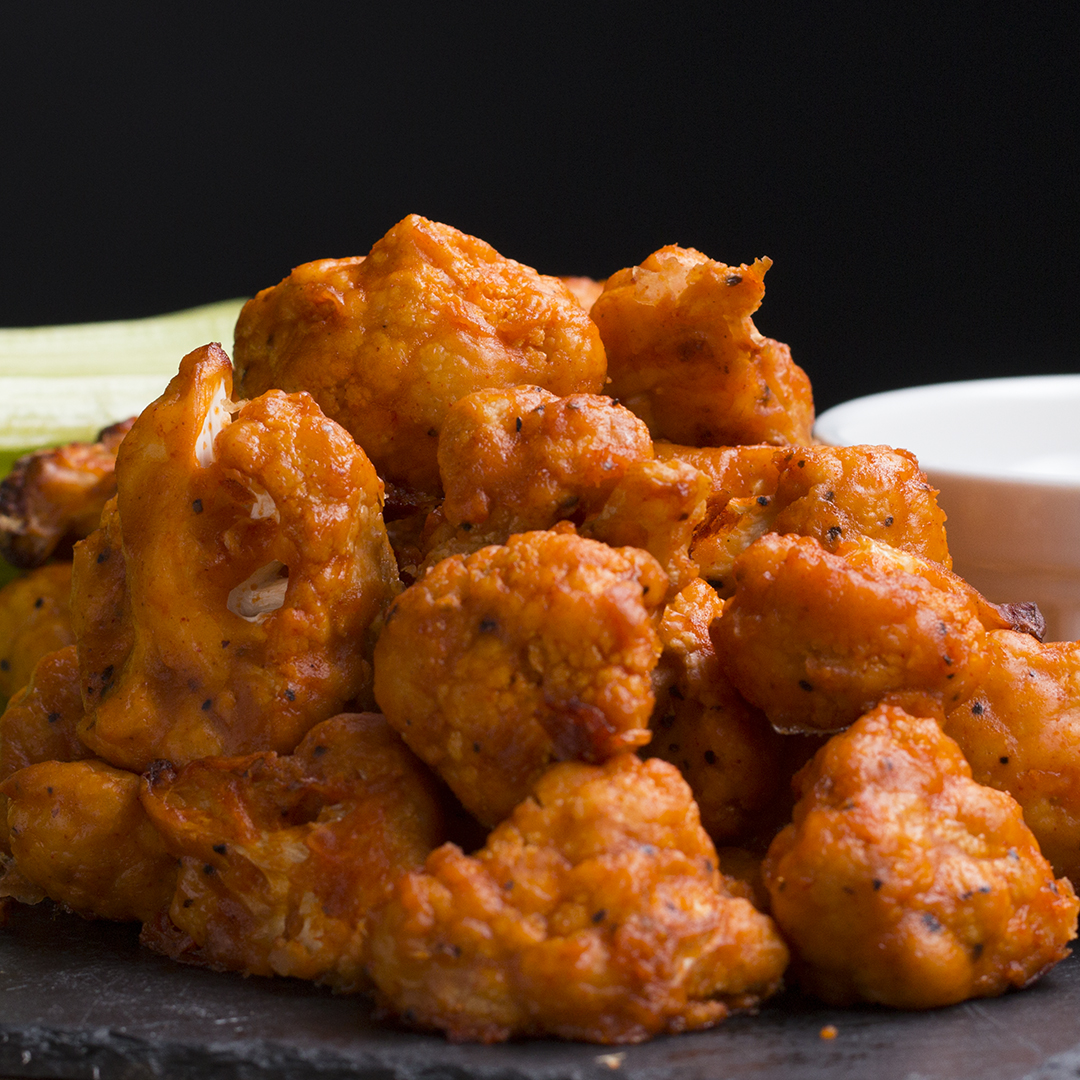 An extreme close-up on a plate of seasoned boneless chicken wings