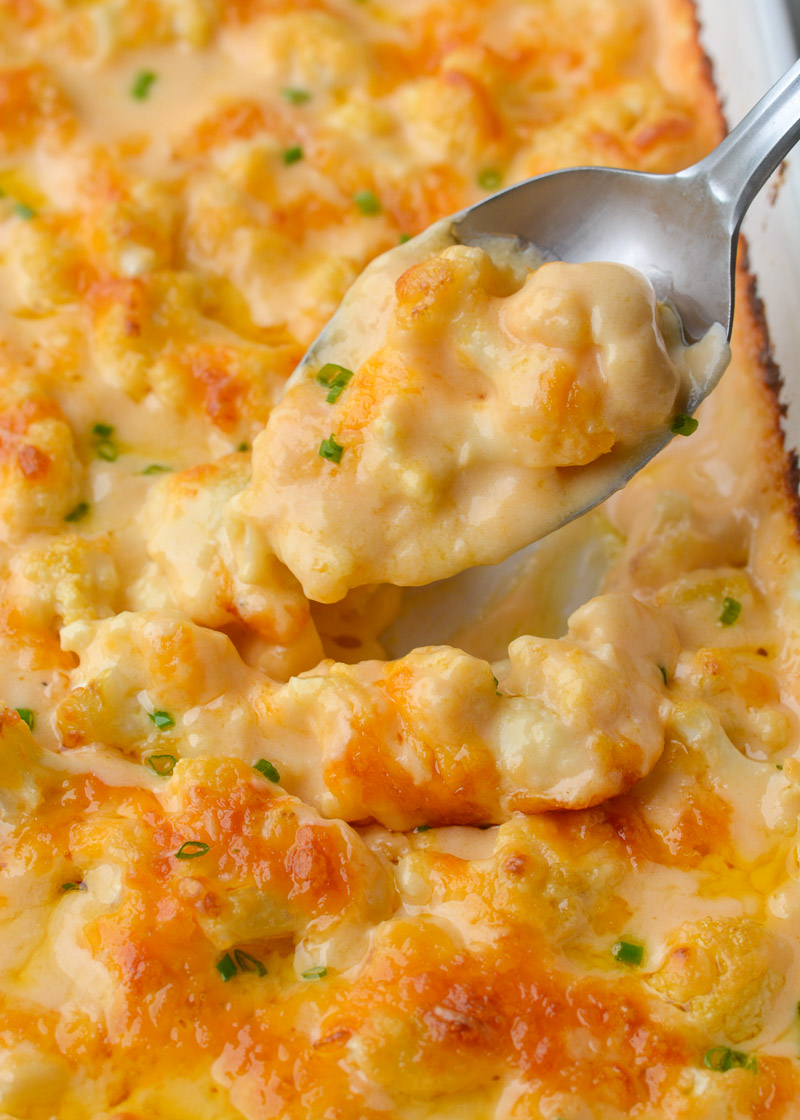 Spoon holding up a bite of cheesy cauliflower casserole - low carb, keto recipe