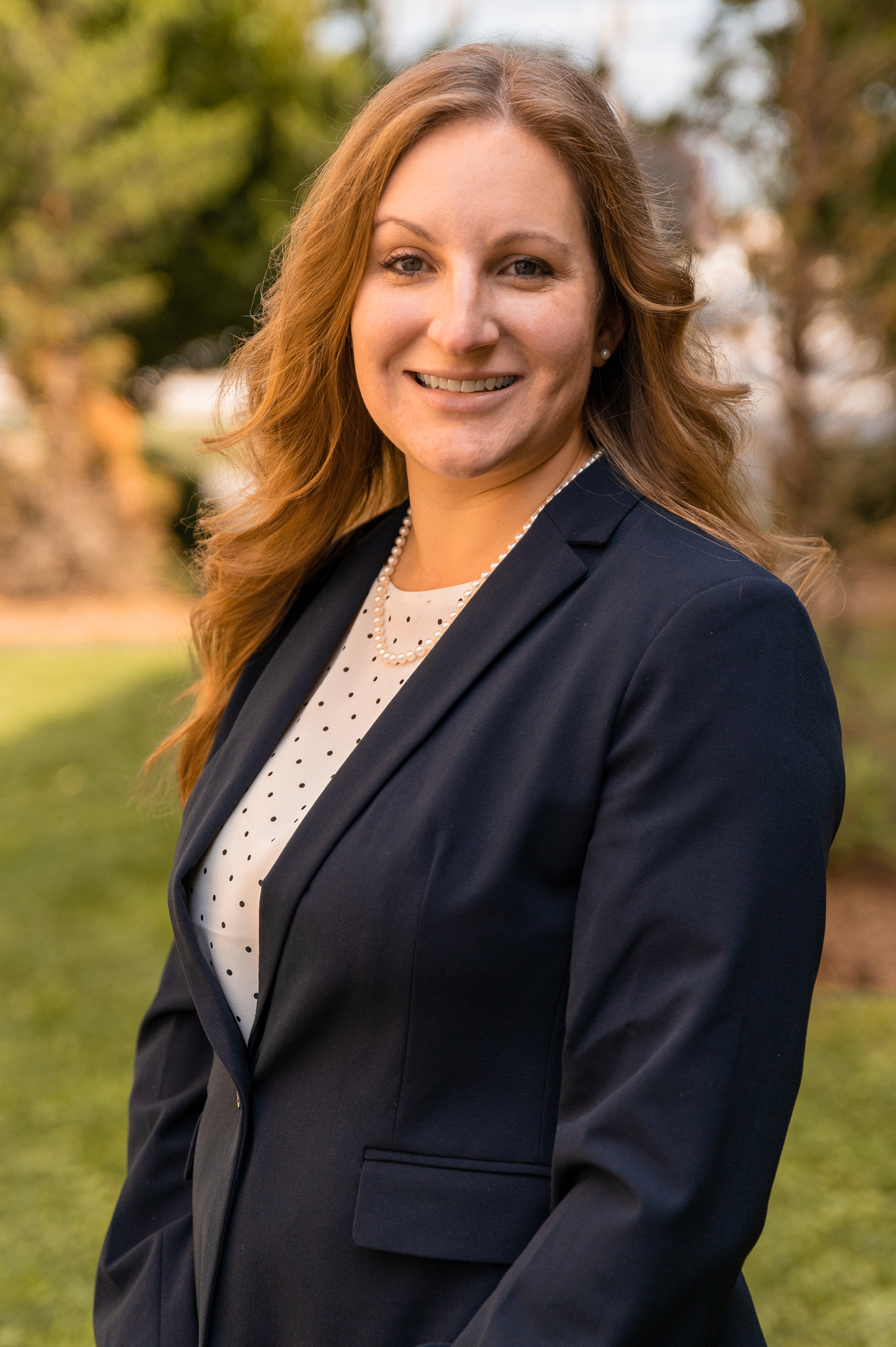 Dr. Hogue, a pale-skinned woman with long blonde hair in a black blazer and a white blouse.