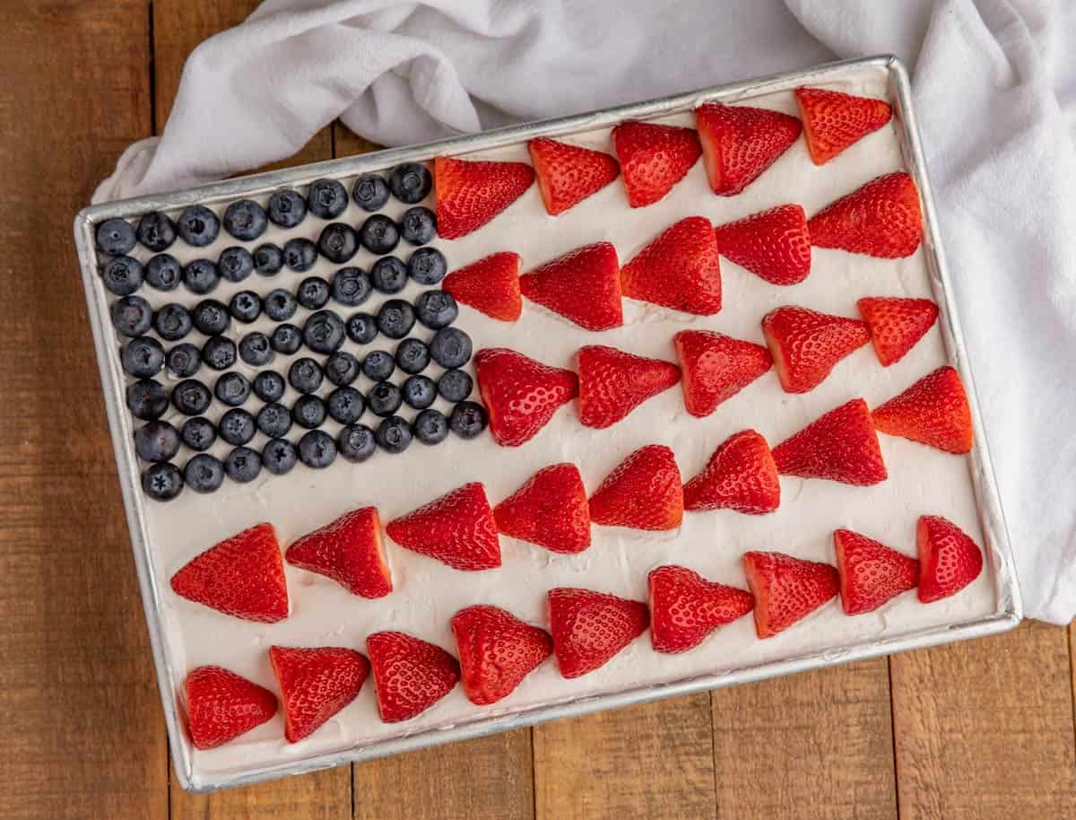 A white-frosted sheet caked with strawberries and blueberries laid on top to resemble the US flag