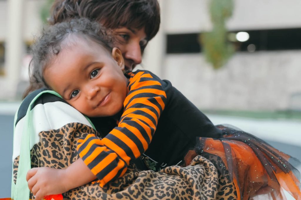 Little girl at local event hugs PHN practitioner