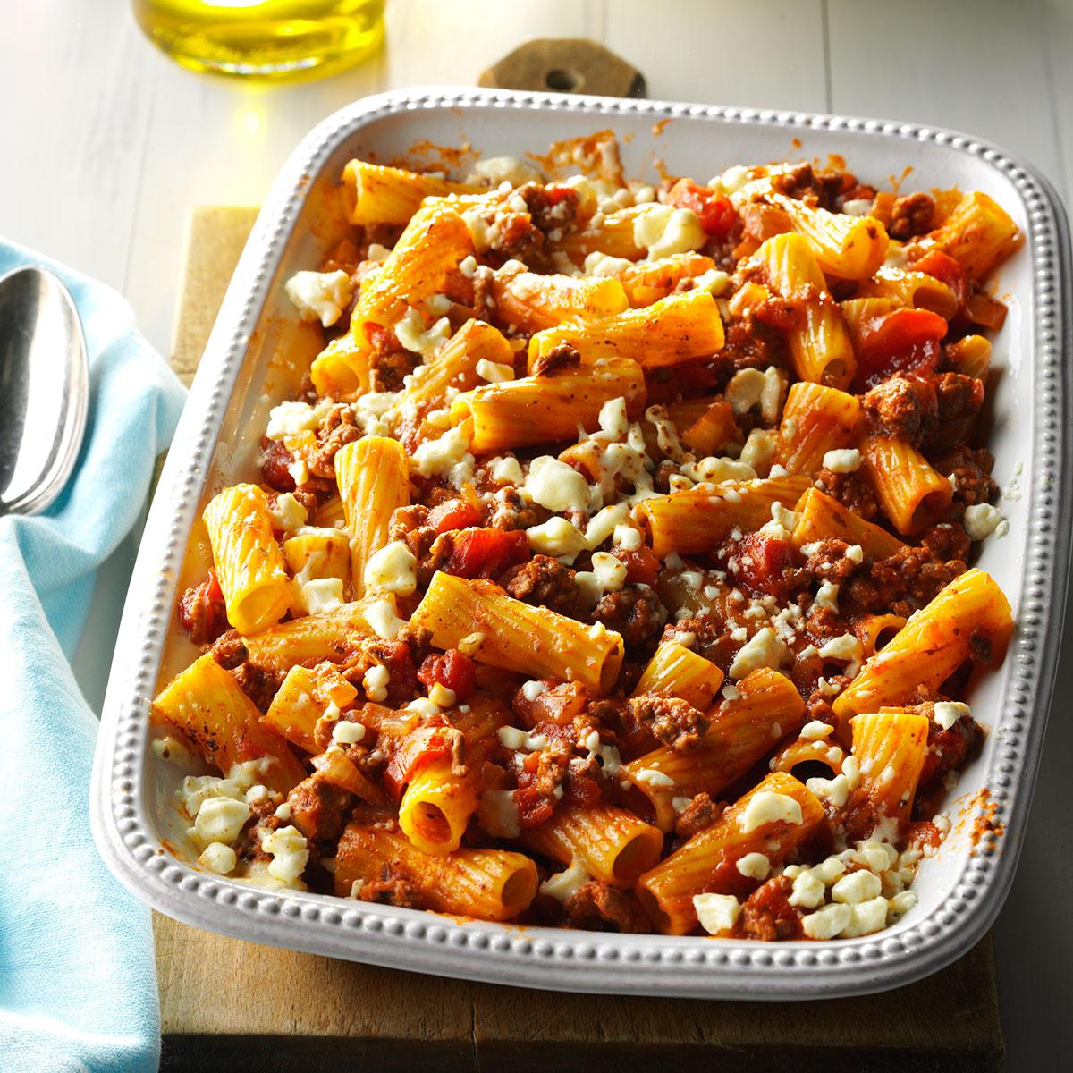 Greek pasta bake. Penne, ground meat, feta, other ingredients in red sauce in a casserole dish