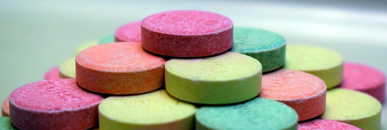An extreme close up of a pyramid made of multicolored Tums tablets