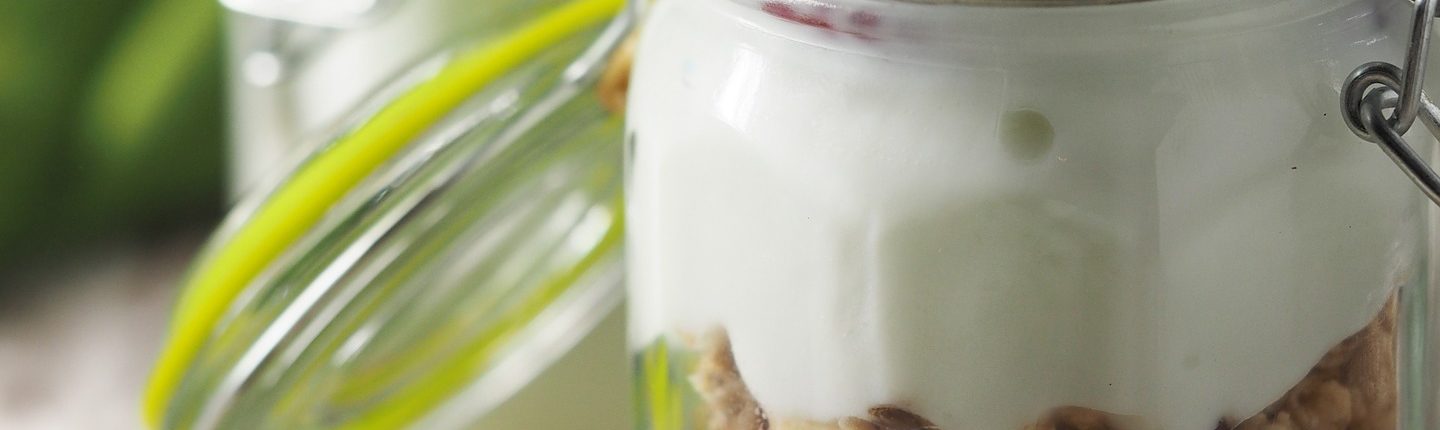 An extreme closeup of yogurt in a glass jar with a hinge lid