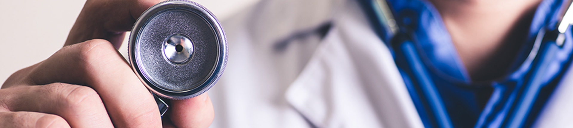 A medical professional wearing a lab coat with the image focused on the stethoscope