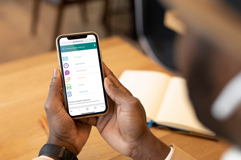 Man holding up a phone and logged into his Primary Health App