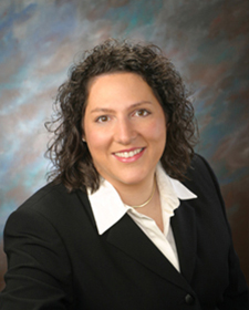 Portrait of Jennie Slabe wearing a dark suit and white collared shirt