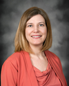 Portrait of Jennifer Wise wearing a peach top and matching cardigan