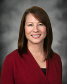 Portrait of Tina Adamson wearing a red sweater over a black top