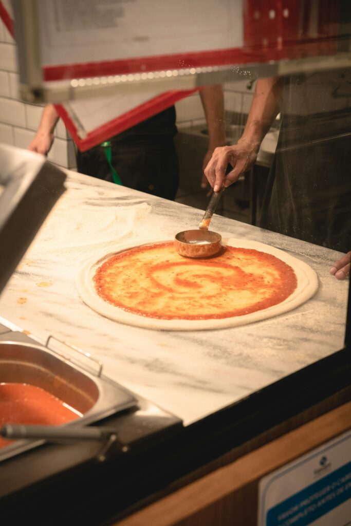 Sausage Pizza with Spinach Salad being made