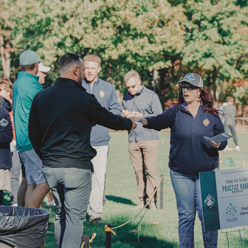 Brittany Fair, Event manager, passing out an award to a male golfer