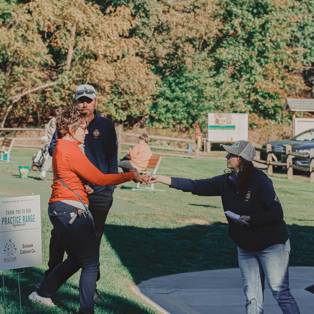 Brittany Fair, event manager, passing out an award to a female golfer