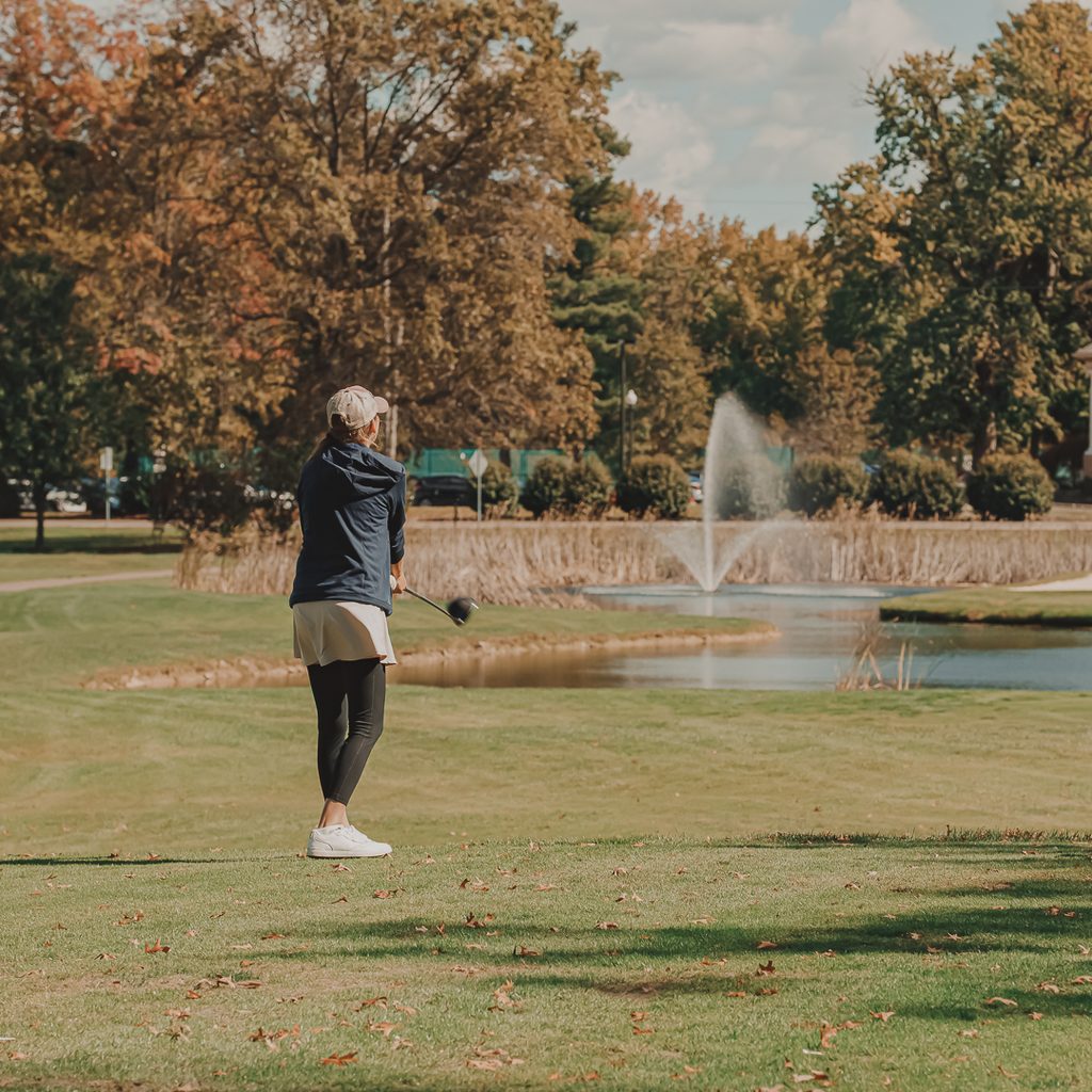 A femal golfer driving