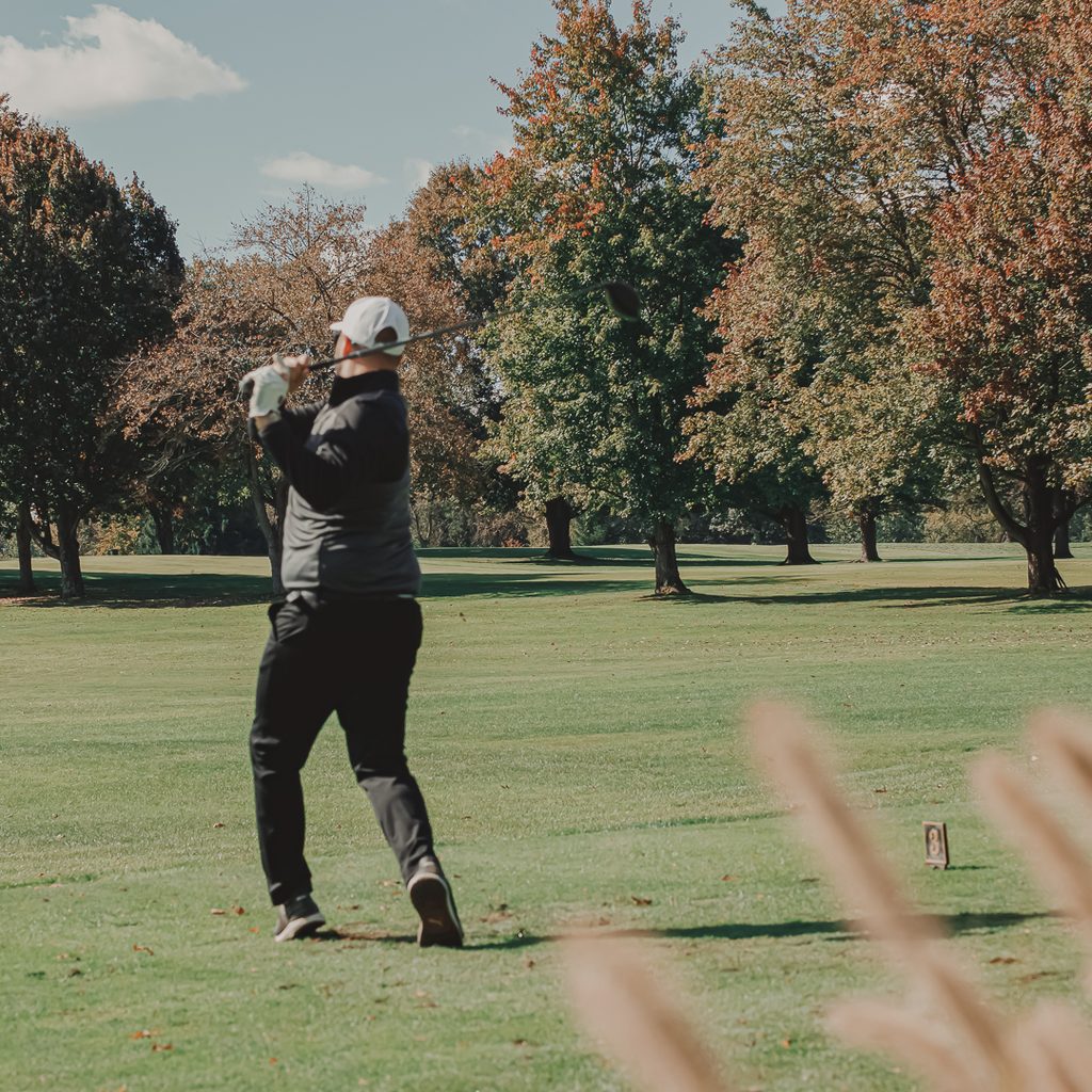 A male golfer hitting from the fairway
