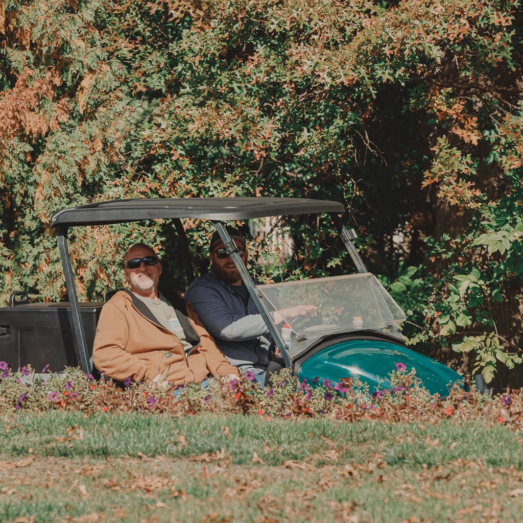 Two golf outing volunteers sitting in a golf cart