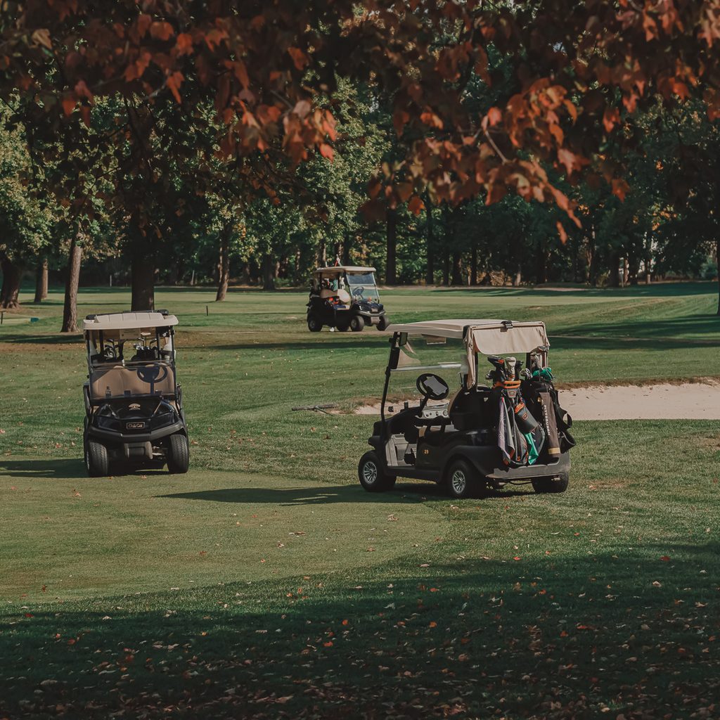 Three golf carts sitting on the golf course