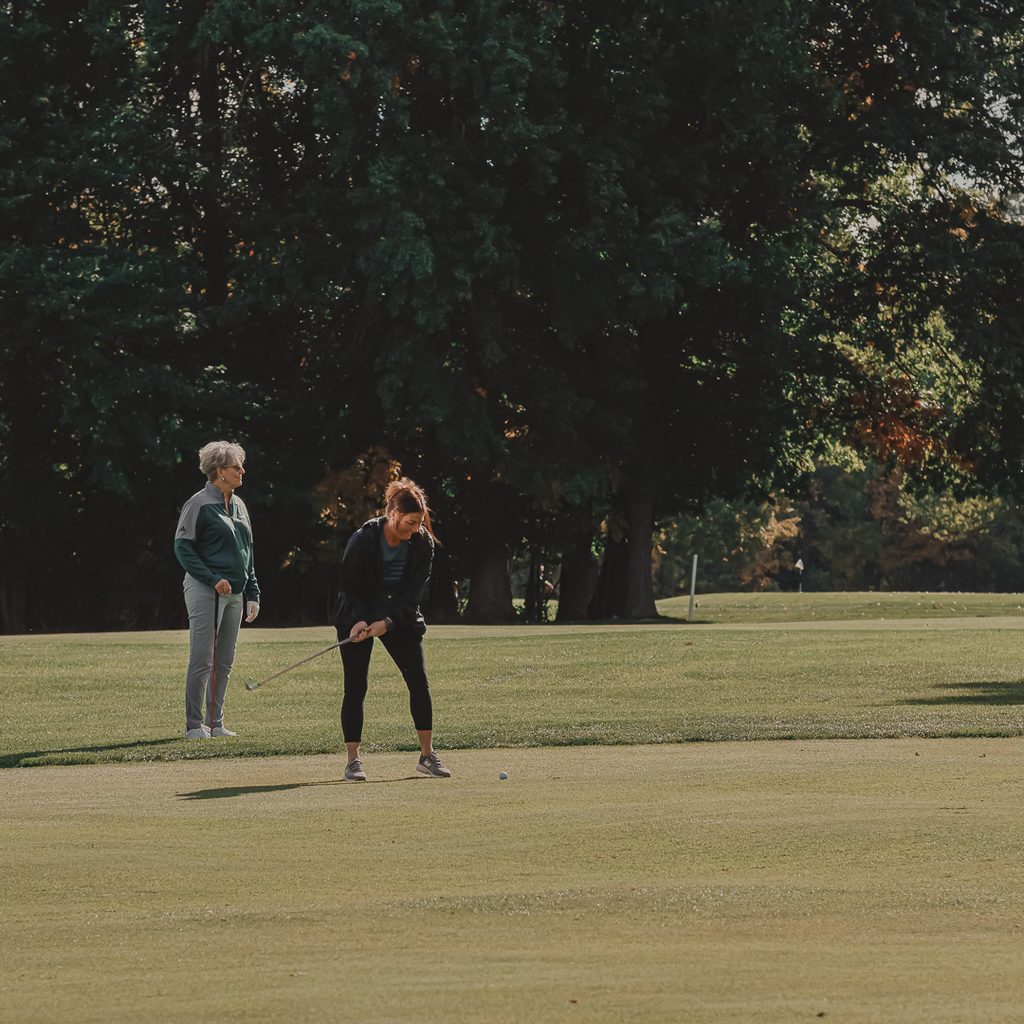 Two femal golfers standing on the fairway