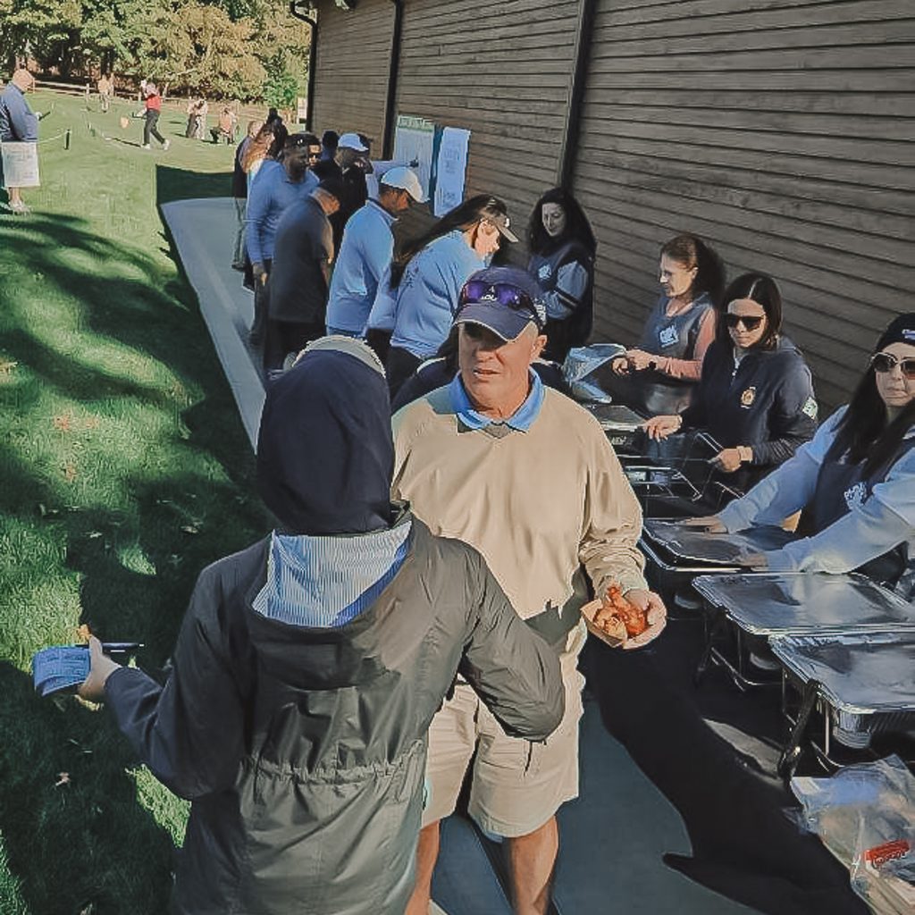 Golfers in line to get food at the events wing buffet