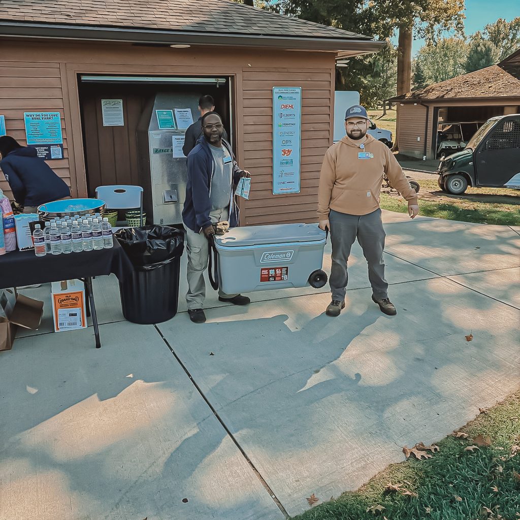 Two male volunteers lifting a cooler