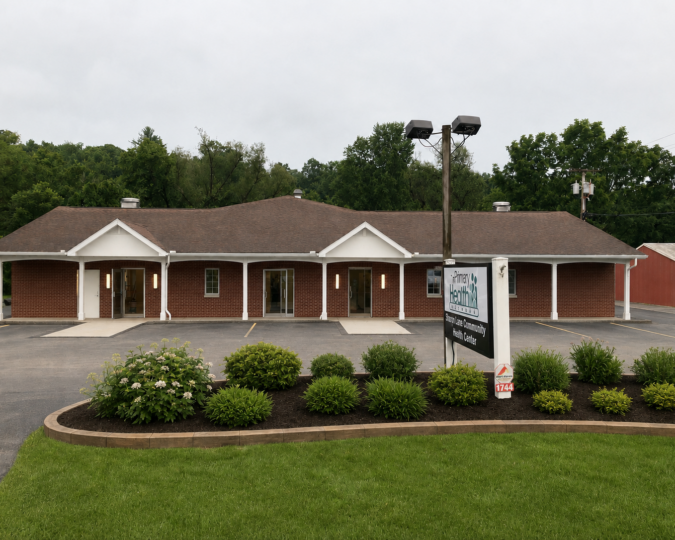 Exterior of Primary Health Network’s Sandy Lake Health Center, featuring a brick building with the health center sign and landscaped entrance.